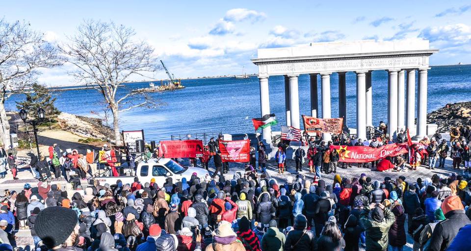 End of National Day of Mourning march at Plymouth rock - many people holding banners